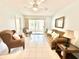 Bright living room featuring tile floors, a ceiling fan, and a sliding glass door to the sunroom at 13926 Mission Oaks Blvd, Seminole, FL 33776