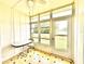 Sunroom features a table and chairs, walls of windows, and a door leading to the exterior at 13926 Mission Oaks Blvd, Seminole, FL 33776
