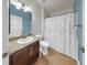Well-lit bathroom featuring a vanity, a toilet, and a shower with a decorative curtain at 14224 Edinburgh Moor Dr, Wimauma, FL 33598