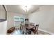 This dining room features a modern chandelier, new flooring, a dark wood table, and cushioned chairs at 14224 Edinburgh Moor Dr, Wimauma, FL 33598