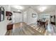Inviting foyer with tiled floor, coat rack, and dining area featuring wood-style flooring and modern chandelier at 14224 Edinburgh Moor Dr, Wimauma, FL 33598