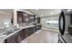 Spacious kitchen with dark cabinets, tiled backsplash, modern appliances, and tile floors at 14224 Edinburgh Moor Dr, Wimauma, FL 33598