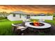 Enjoy cozy evenings in this backyard with a fire pit and seating, against a dramatic sunset backdrop at 14320 Tree Swallow Way, Lakewood Ranch, FL 34202