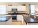 Bright kitchen featuring stainless steel appliances, dark countertops, and ample cabinet space at 14320 Tree Swallow Way, Lakewood Ranch, FL 34202