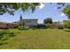 Spacious backyard with lush green lawn, screen patio, and mature landscaping at 167 Almedo Ne Way, St Petersburg, FL 33704