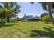 Well-maintained backyard with a screen patio, lawn, and mature landscaping at 167 Almedo Ne Way, St Petersburg, FL 33704