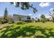 Large backyard with mature shade trees, green lawn, and screened lanai at 167 Almedo Ne Way, St Petersburg, FL 33704