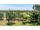 Expansive backyard featuring lush green grass and mature trees overlooking a pond and golf course at 167 Almedo Ne Way, St Petersburg, FL 33704
