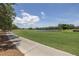 Scenic golf course view with a paved path amidst lush green fairways and a serene pond at 167 Almedo Ne Way, St Petersburg, FL 33704