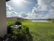 Expansive backyard with a serene lake view and lush greenery at 17304 Scuba Crest St, Wimauma, FL 33598
