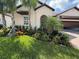 Home exterior with mature landscaping, a paver driveway and an open garage at 17304 Scuba Crest St, Wimauma, FL 33598