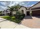 Attractive home featuring a paver driveway and tropical landscaping at 17304 Scuba Crest St, Wimauma, FL 33598