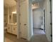 Hallway leading to bathroom with entry nook, and light tiled floors at 17304 Scuba Crest St, Wimauma, FL 33598