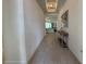 Hallway with neutral colored walls and floors leading into the living room, with decorative table at 17304 Scuba Crest St, Wimauma, FL 33598