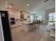 Modern kitchen with stainless steel appliances, an island, and an adjacent dining area at 17304 Scuba Crest St, Wimauma, FL 33598