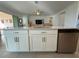 Kitchen island with white cabinets, stainless steel appliances and sink at 17304 Scuba Crest St, Wimauma, FL 33598