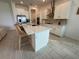 Modern kitchen with white cabinetry, stainless steel appliances, and a kitchen island at 17304 Scuba Crest St, Wimauma, FL 33598