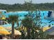 People enjoying the sunny lagoon with inflatable structures, kayaks, and lifeguard stations at 17304 Scuba Crest St, Wimauma, FL 33598