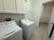 Functional laundry room with modern washer and dryer units and storage cabinets at 17304 Scuba Crest St, Wimauma, FL 33598