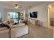 Cozy living room with ceiling fan, TV, comfortable seating, and natural light at 17304 Scuba Crest St, Wimauma, FL 33598