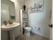 Well-lit powder room featuring a pedestal sink, toilet and decor at 17304 Scuba Crest St, Wimauma, FL 33598