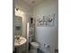 Well-lit powder room featuring a pedestal sink, toilet and decor at 17304 Scuba Crest St, Wimauma, FL 33598