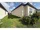 Side yard with well-maintained landscaping and an air conditioning unit at 17304 Scuba Crest St, Wimauma, FL 33598