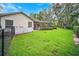 Fenced backyard with lush grass, landscaping, and a view of the home's exterior and screened porch at 17802 Mission Oak Dr, Lithia, FL 33547