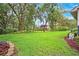 This sprawling backyard with lush greenery offers a tranquil view of the screened pool and the home's exterior at 17802 Mission Oak Dr, Lithia, FL 33547