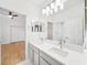Bathroom with double vanity and bright lighting open to bedroom at 17802 Mission Oak Dr, Lithia, FL 33547