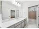 Bathroom with white countertops, large mirror, and a doorway into a bedroom at 17802 Mission Oak Dr, Lithia, FL 33547