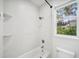 Clean, bright bathroom features a bathtub and window for natural light at 17802 Mission Oak Dr, Lithia, FL 33547