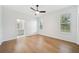 Bright bedroom featuring hardwood floors, ceiling fan, and a glimpse into an attached bathroom at 17802 Mission Oak Dr, Lithia, FL 33547