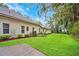 Exterior view of the home showcasing the manicured lawn, garden beds, and a glimpse of the serene backyard at 17802 Mission Oak Dr, Lithia, FL 33547