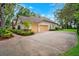 Spacious three-car garage with concrete driveway and manicured landscaping at 17802 Mission Oak Dr, Lithia, FL 33547