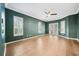 Living room with green walls, crown molding, shutters, wood floors, and ceiling fan at 17802 Mission Oak Dr, Lithia, FL 33547