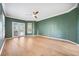 Bright living room with green walls, crown molding, shutters, wood floors, and ceiling fan at 17802 Mission Oak Dr, Lithia, FL 33547