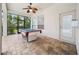 Covered patio featuring a ceiling fan, brick flooring, and a pool table for outdoor entertainment at 17802 Mission Oak Dr, Lithia, FL 33547