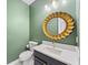 Stylish powder room with a unique gold mirror and modern fixtures at 17802 Mission Oak Dr, Lithia, FL 33547
