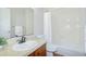 Bathroom with dark wood vanity, white tile shower and decorative mirror at 1799 N Highland Ave # 185, Clearwater, FL 33755