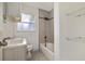 The bathroom features a tiled shower-tub combo, updated vanity, and convenient shelving at 2204 E Idlewild Ave, Tampa, FL 33610