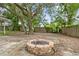 Charming backyard with a rustic fire pit surrounded by mature trees at 2204 E Idlewild Ave, Tampa, FL 33610