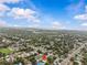 Aerial shot of the property and its tree-filled neighborhood with clear blue skies offering a peaceful setting at 2465 16Th S Ave, St Petersburg, FL 33712