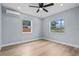 Empty bedroom features a ceiling fan, mini-split air conditioner, wood-look floors and two windows at 2465 16Th S Ave, St Petersburg, FL 33712