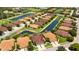 This aerial view captures a beautiful, well-maintained single Gathering home with a lush green lawn and a nearby community lake at 2527 Terracina Dr, Venice, FL 34292