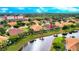 Aerial view of homes with screened lanais, water view, and lush greenery at 2527 Terracina Dr, Venice, FL 34292