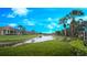 Lush green backyard overlooking a tranquil pond, perfect for relaxing and enjoying the scenery at 2527 Terracina Dr, Venice, FL 34292