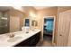 Large bathroom with double vanity and mirrors and view to bedroom at 2527 Terracina Dr, Venice, FL 34292