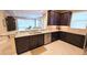 Kitchen with granite counters, dark wood cabinets, and stainless steel appliances opens to the living room at 2527 Terracina Dr, Venice, FL 34292