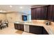 Kitchen with granite countertops, stainless steel appliances, and dark wood cabinets; open to living spaces at 2527 Terracina Dr, Venice, FL 34292